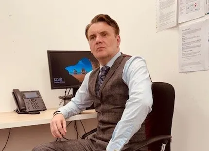 Our session supervisor at Hamilton Citizens Advice sitting at his desk in the office.